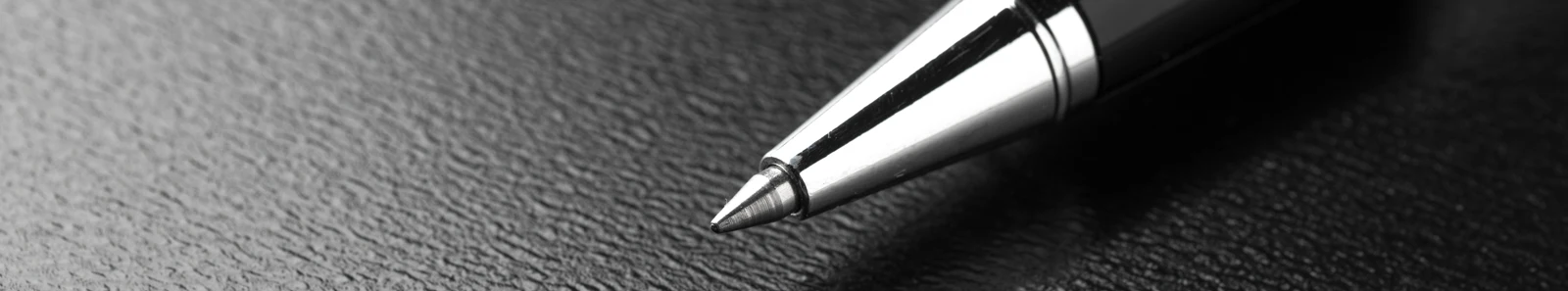Close up picture of ball point pen on leather case