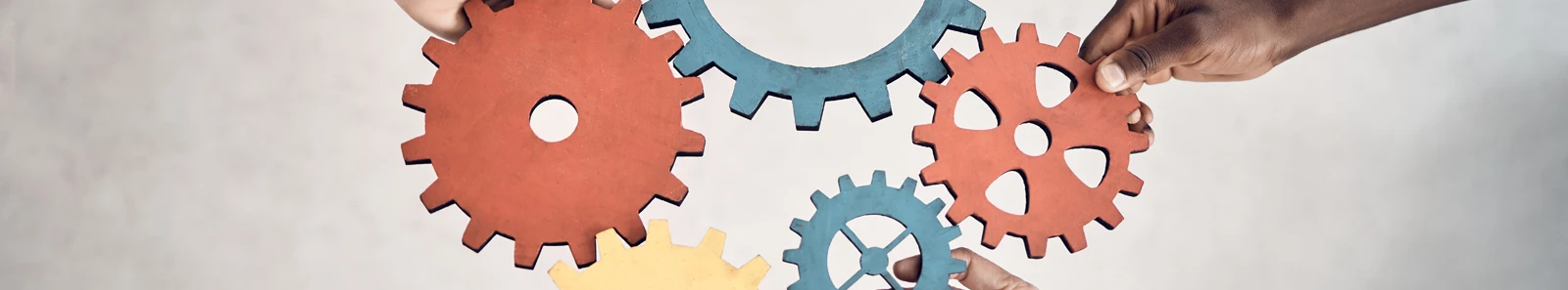 Picture of 5 cogs joined, held in place by hands